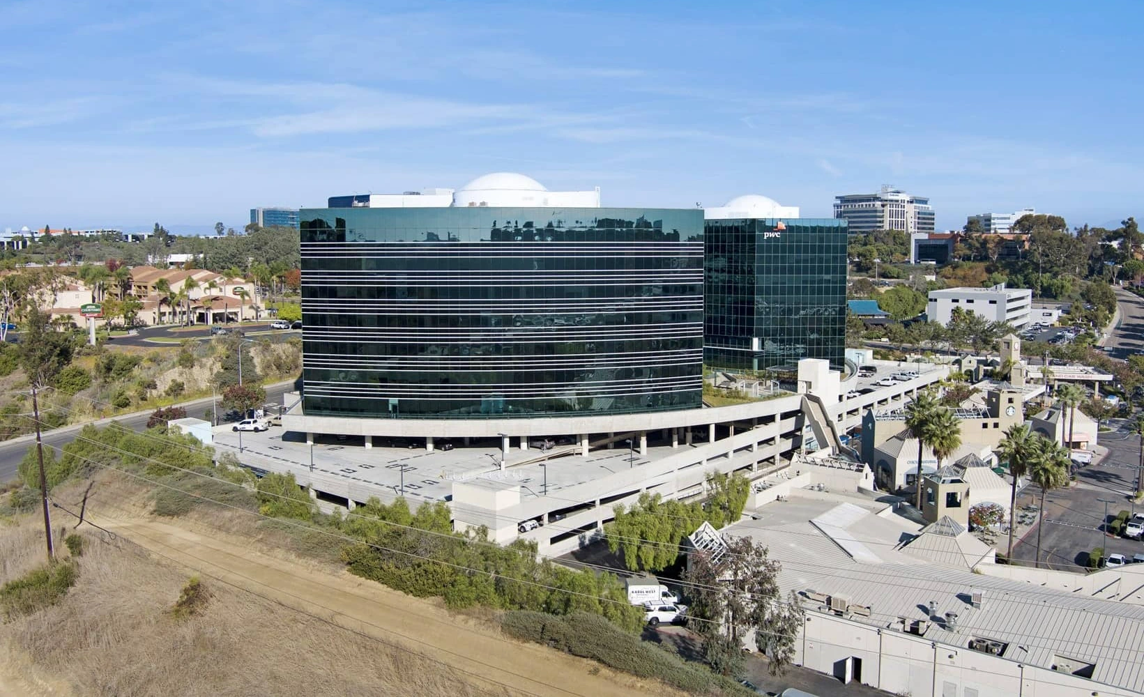Sorrento Towers in San Diego, California. Two curved glass office towers above the entry plaza and retail in Sorrento Mesa. San Diego office real estate.