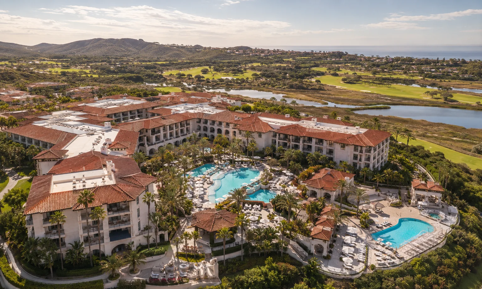 Four Seasons Aviara Carlsbad. Aerial of the resort with its pools, golf fairways, and the Batiquitos Lagoon and coast beyond. Master-planned coastal community California.