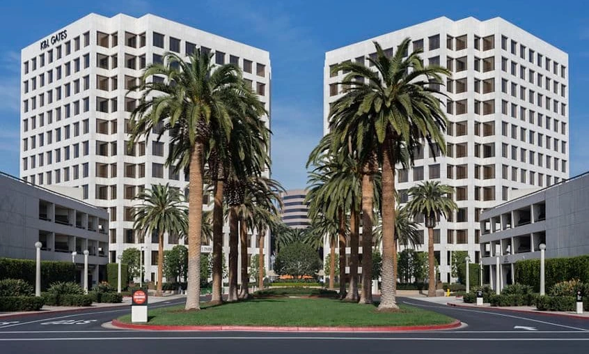 Ground level at the entry. The twin towers framed by the palm-lined approach off the John Wayne corridor.