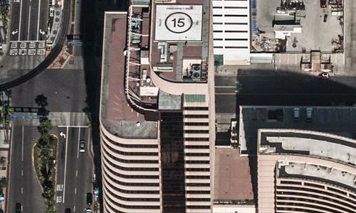 Shoreline Square Long Beach. Overhead aerial of the curved Class A office tower with rooftop helipad and the plaza in downtown Long Beach. Long Beach waterfront office real estate.