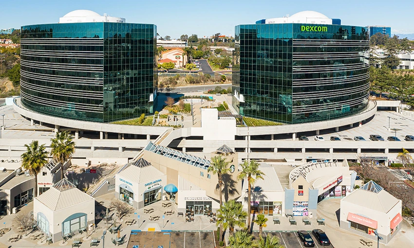 Sorrento Towers San Diego. Aerial of the curved glass towers and amenity retail in Sorrento Mesa. Southern California office real estate developer.